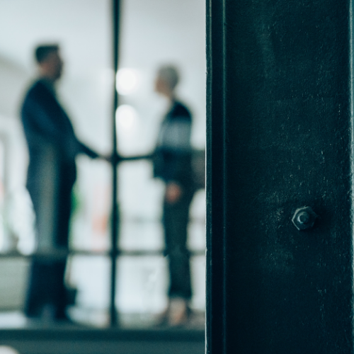 Two men shaking hands in a meeting