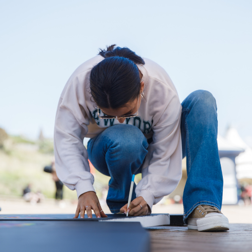 A woman writing a message at the Messages of Hope 2023 event